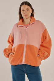 A model wearing the Jayne Fleece Jacket in colour Pinkorange (Pink), from the front, cropped image