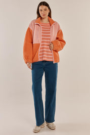 A model wearing the Jayne Fleece Jacket in colour Pinkorange (Pink), from the front, showing the whole outfit