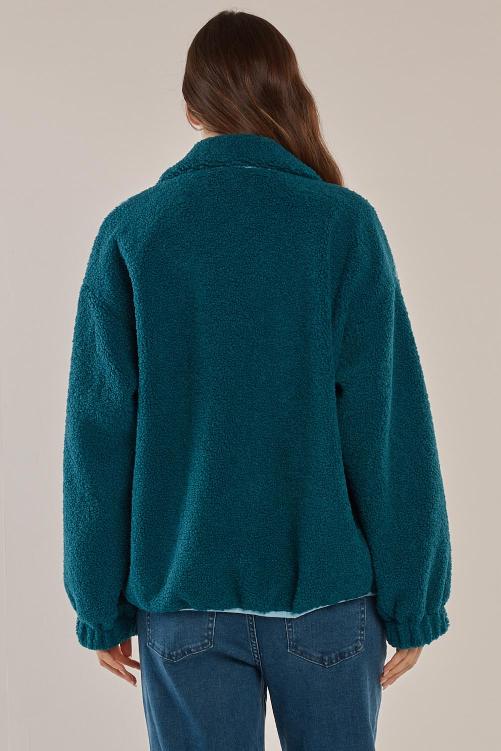 A model wearing the Jayne Fleece Jacket in colour Tealblue (Blue), from the back