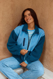 A model wearing the Jayne Fleece Jacket in colour Tealblue (Blue), from the front, showing the whole outfit