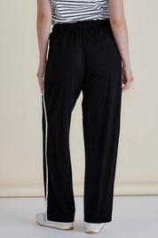 A model wearing the Evelyn Wide Leg Jogger in colour Blacktrim (Black), from the back