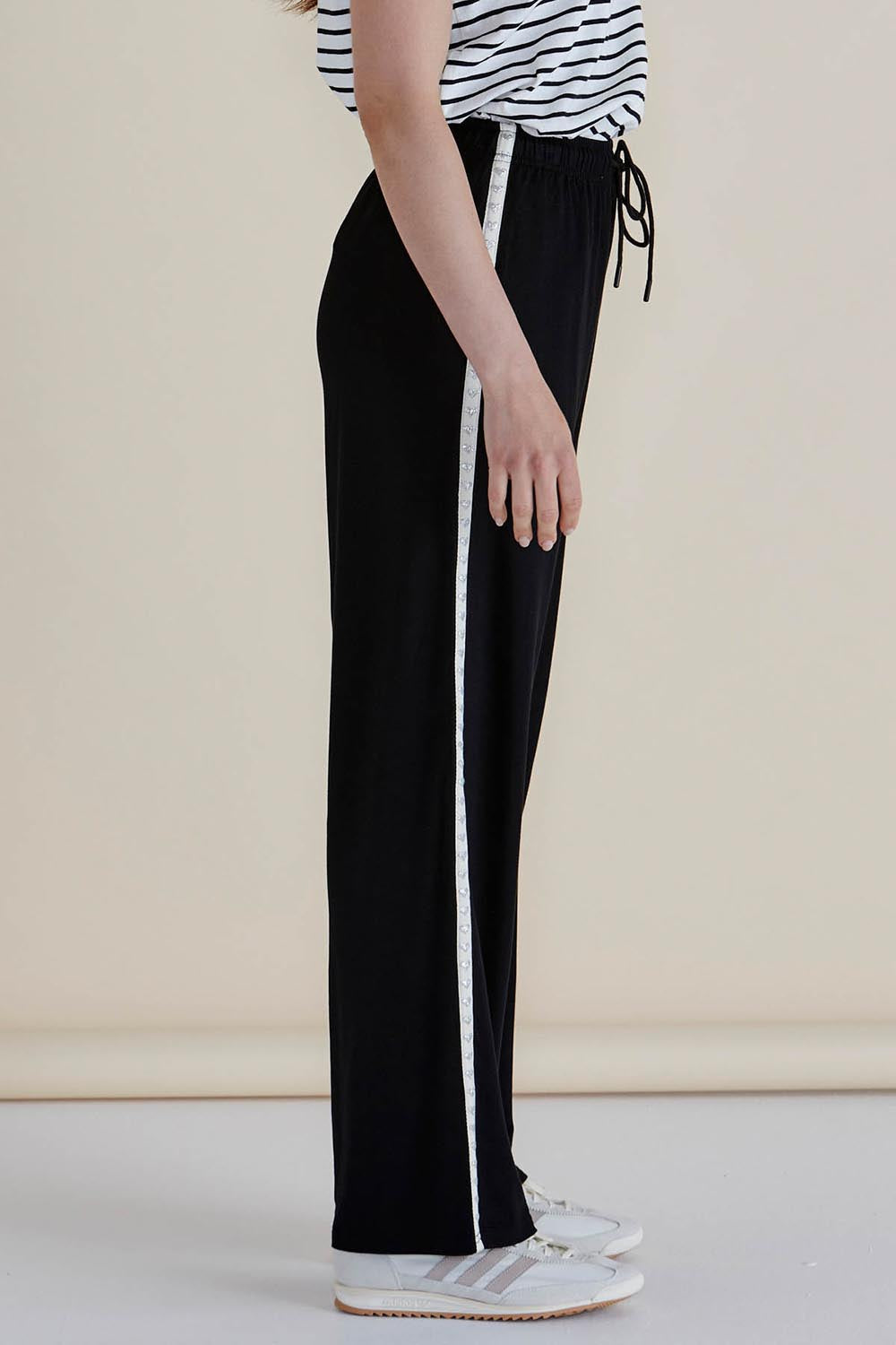 A model wearing the Evelyn Wide Leg Jogger in colour Blacktrim (Black), from the front, cropped image