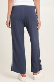 Model Madeline wearing size 10 of the Evelyn Wide Leg Jogger in colour Petrol (Blue), from the back