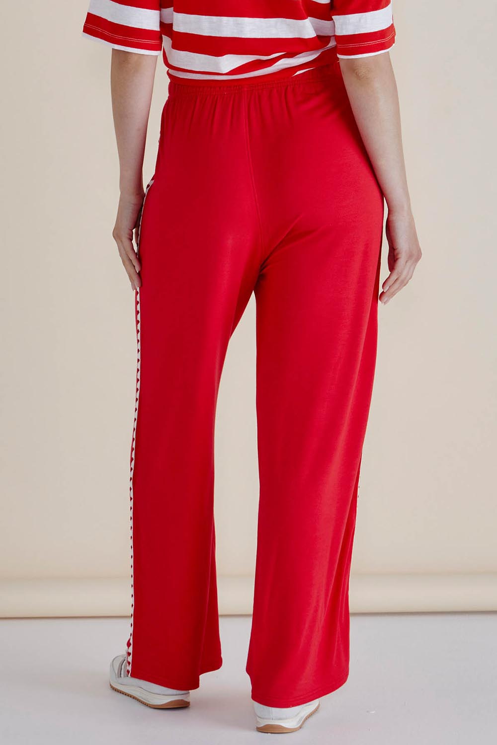 A model wearing the Evelyn Wide Leg Jogger in colour Redtrim (Red), from the back
