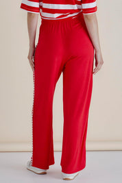 A model wearing the Evelyn Wide Leg Jogger in colour Redtrim (Red), from the back