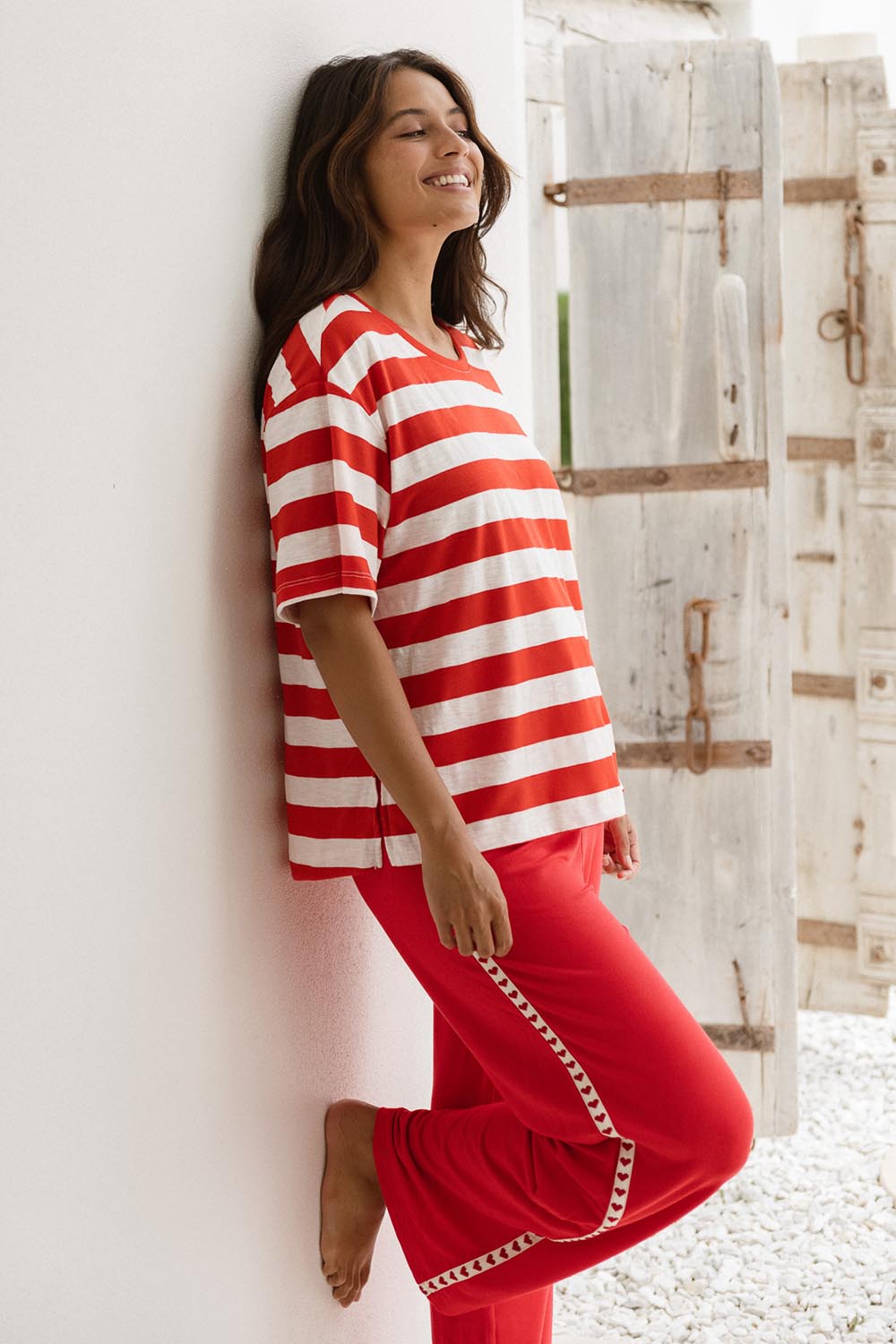 A model wearing the Evelyn Wide Leg Jogger in colour Redtrim (Red), from the front, showing the whole outfit
