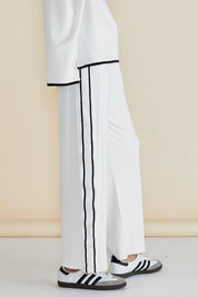 A model wearing the Evelyn Wide Leg Jogger in colour White (White), from the front, cropped image