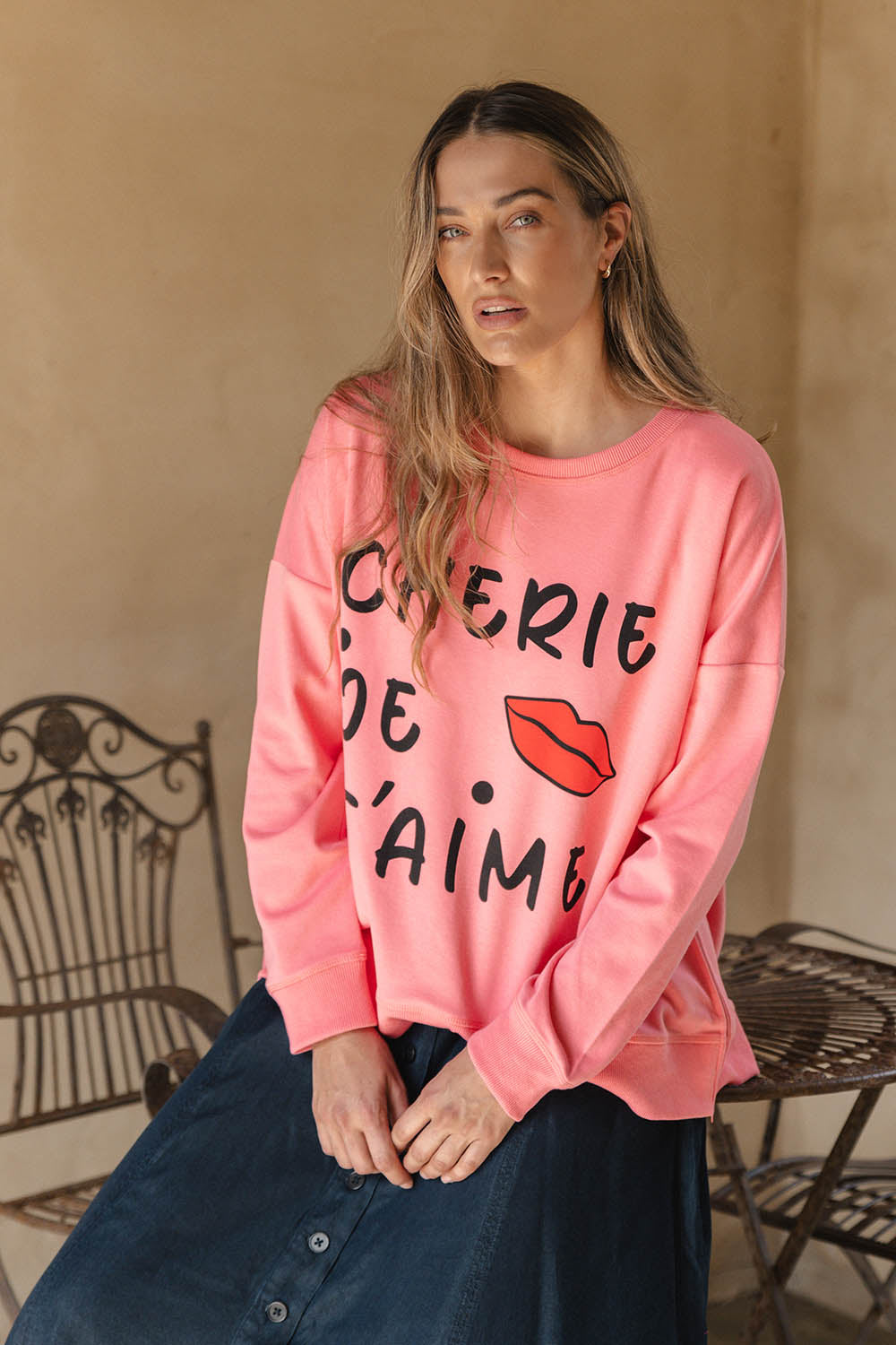 A model wearing the Sonya Cotton Blend Sweat in colour Loveprint (Pink), from the front, showing the whole outfit