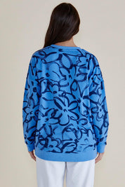 A model wearing the Palma Sweat in colour Bluefloral (Blue), from the back