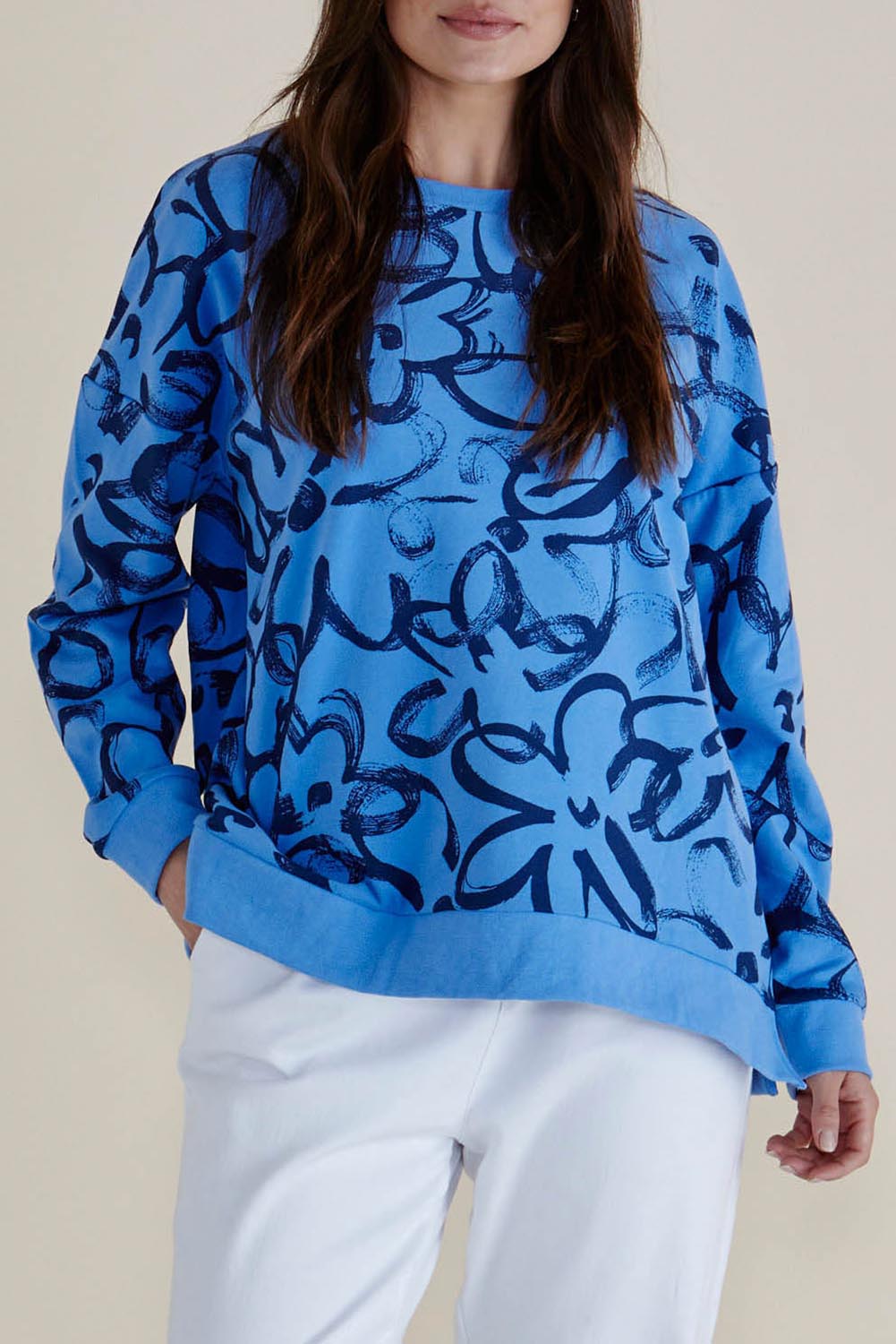 A model wearing the Palma Sweat in colour Bluefloral (Blue), from the front, cropped image