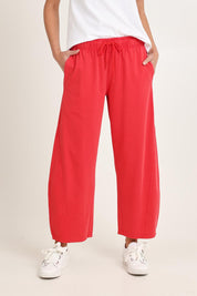 Model Madeline wearing size 10 of the Barrel Leg Cotton Sweatpant in colour Red (Red), from the front, cropped image