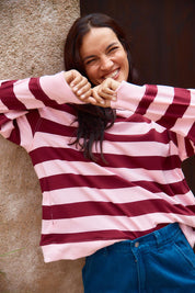 A model wearing the Stazie Sweatshirt in colour Pinkred (Pink), from the front, cropped image