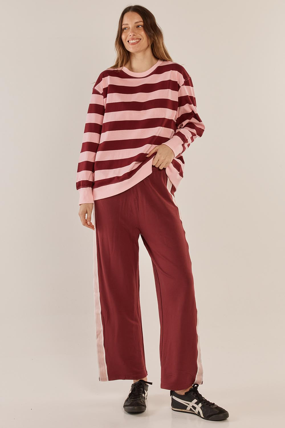 A model wearing the Stazie Sweatshirt in colour Pinkred (Pink), from the front, showing the whole outfit