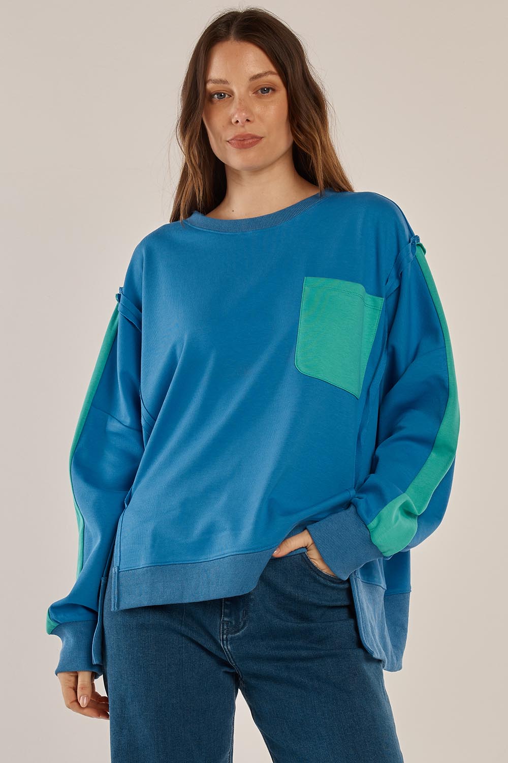 A model wearing the Tania Sweatshirt in colour Bluegreen (Blue), from the front, cropped image