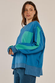 A model wearing the Tania Sweatshirt in colour Bluegreen (Blue), from the front, cropped image