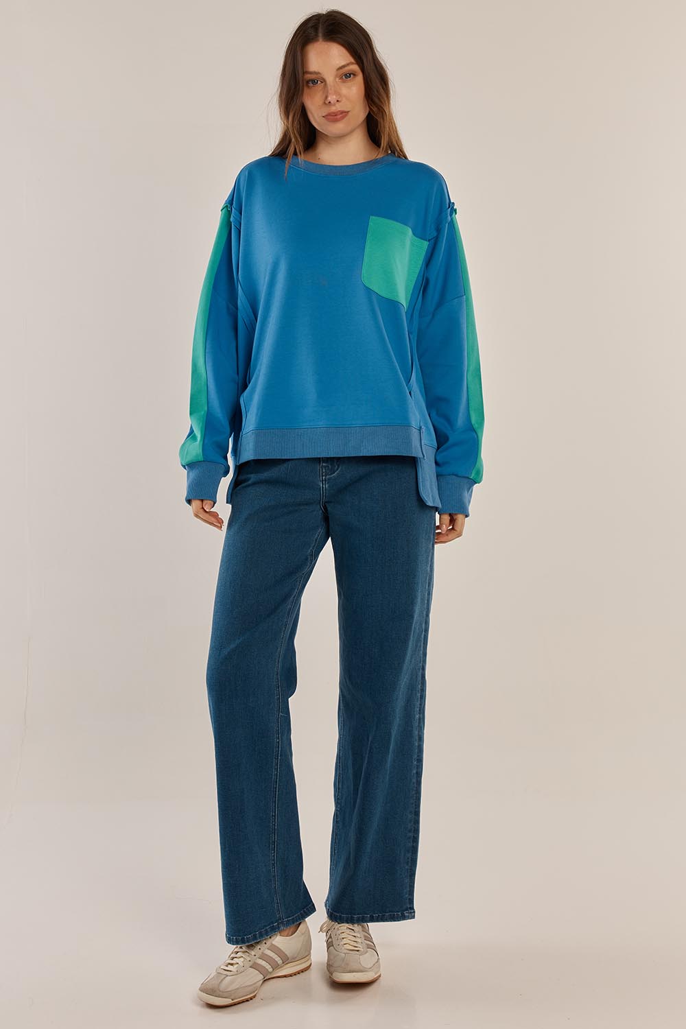 A model wearing the Tania Sweatshirt in colour Bluegreen (Blue), from the front, showing the whole outfit