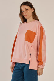 A model wearing the Tania Sweatshirt in colour Pinkorange (Pink), from the front, cropped image