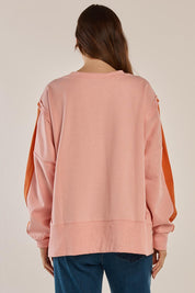 A model wearing the Tania Sweatshirt in colour Pinkorange (Pink), from the front, cropped image