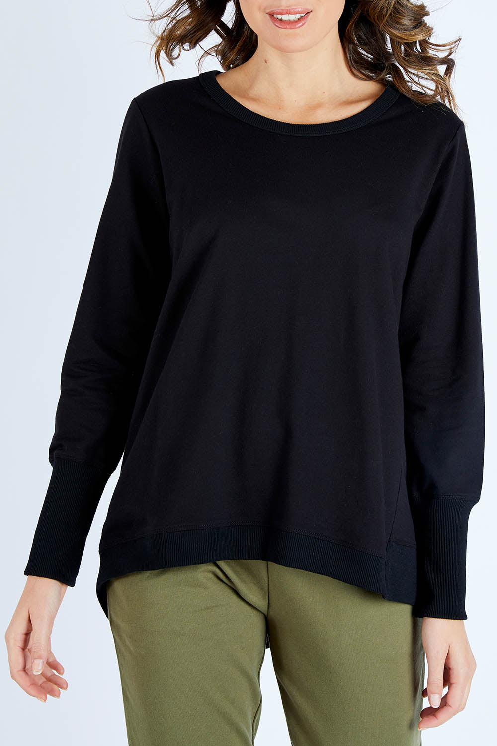 Model Madeline wearing size 10 of the Dolly Sweat in colour Black (Black), from the front, cropped image