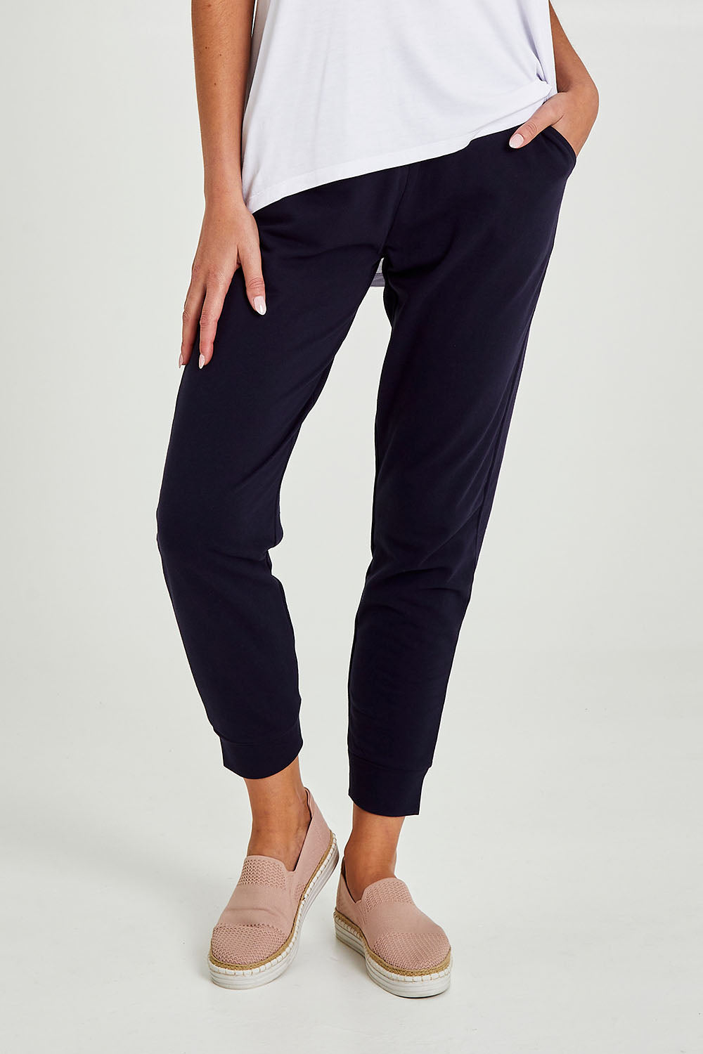 Model Madeline wearing size 10 of the Lindsay Jogger in colour Navy (Blue), from the front, cropped image