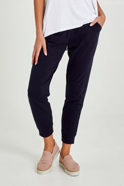 Model Madeline wearing size 10 of the Lindsay Jogger in colour Navy (Blue), from the front, cropped image