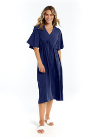 A model wearing the Cora Cotton Dress in colour Frenchblue (Blue), from the front, showing the whole outfit