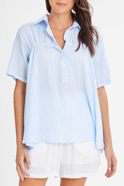 Model Madeline wearing size 10 of the Sydney Smock Shirt in colour Blueseer (Blue), from the front, cropped image