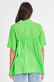 Model Madeline wearing size 10 of the Sydney Smock Shirt in colour Green (Green), from the back