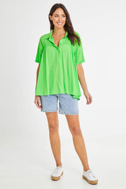 Model Madeline wearing size 10 of the Sydney Smock Shirt in colour Green (Green), from the front, showing the whole outfit
