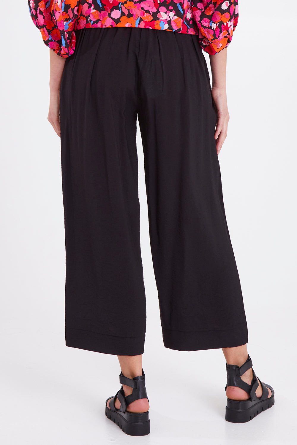 Model Madeline wearing size 10 of the Sarah Pant in colour Black (Black), from the back
