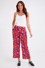Model Madeline wearing size 10 of the Sarah Pant in colour Brushflora (Pink), from the front, showing the whole outfit