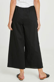 Model Madeline wearing size 10 of the Lulu Pant in colour Black (Black), from the back