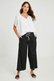 Model Madeline wearing size 10 of the Lulu Pant in colour Black (Black), from the front, showing the whole outfit