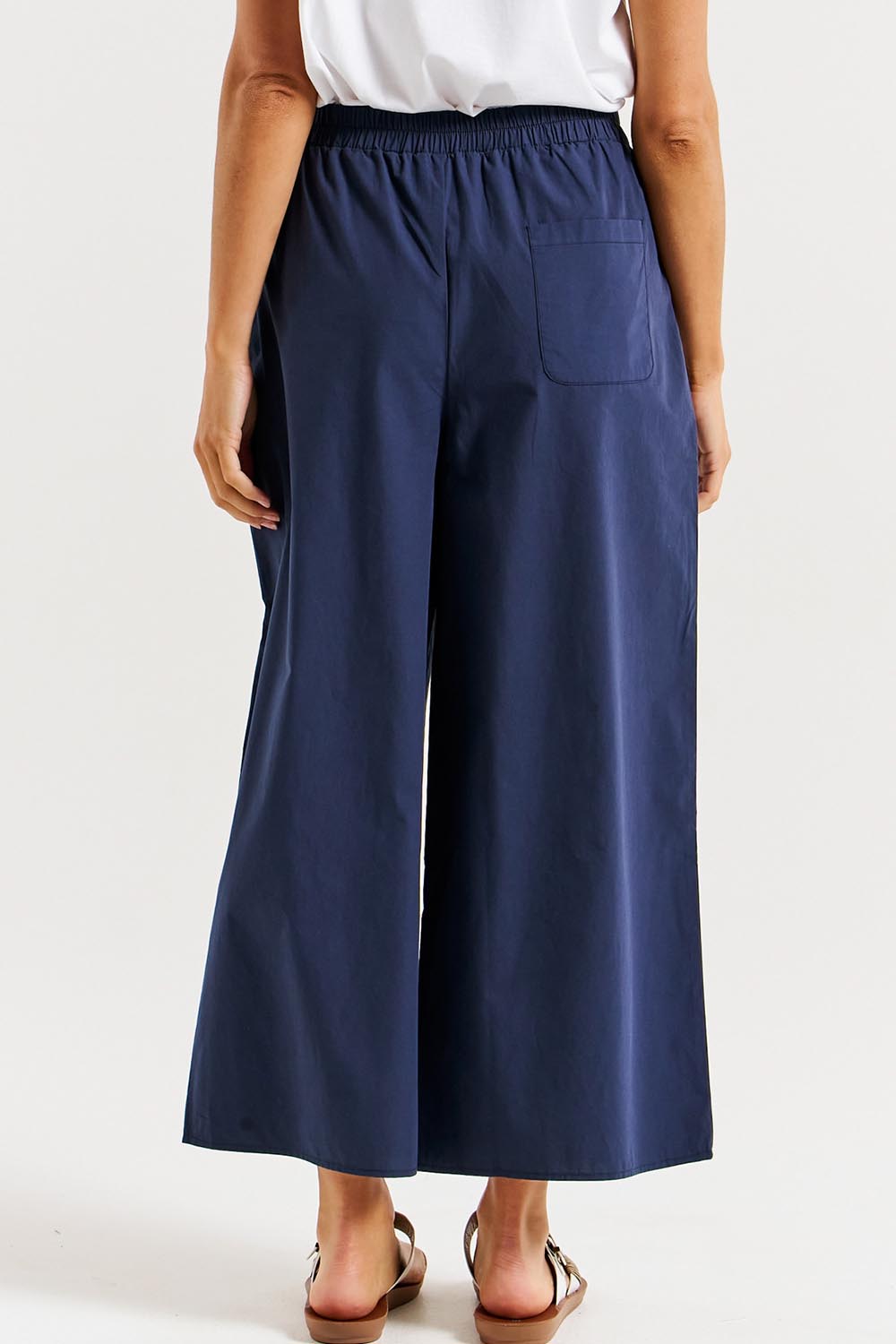 A model wearing the Lulu Cotton Pant in colour Navy (Blue), from the back