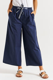 A model wearing the Lulu Cotton Pant in colour Navy (Blue), from the front, cropped image