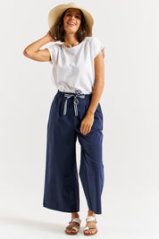 A model wearing the Lulu Cotton Pant in colour Navy (Blue), from the front, showing the whole outfit