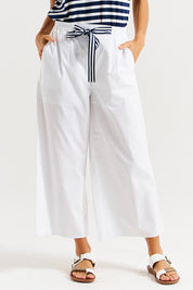 A model wearing the Lulu Cotton Pant in colour White (White), from the front, cropped image