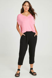 Model Madeline wearing size 10 of the Positano Linen Pant in colour Black (Black), from the front, showing the whole outfit