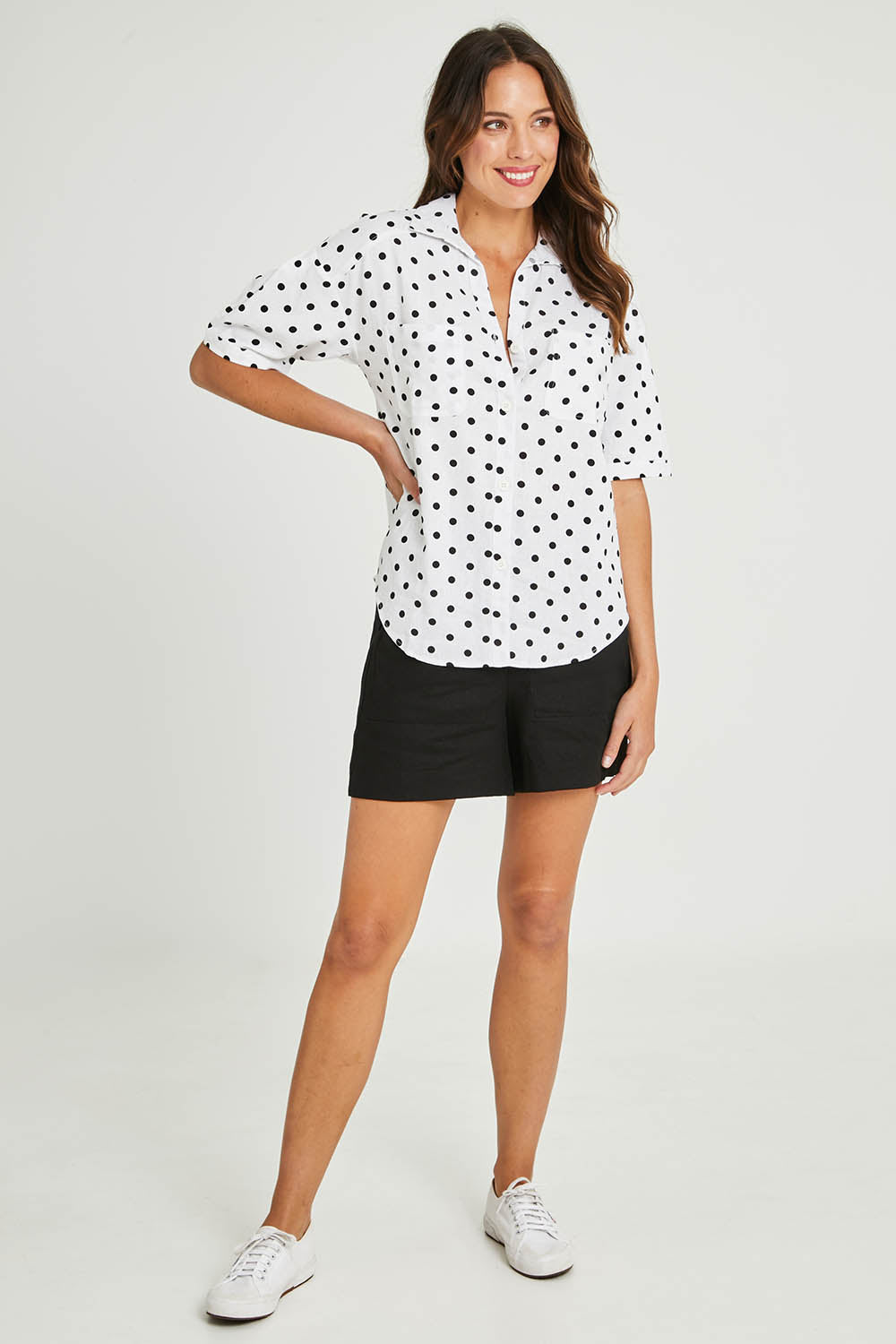 Model Madeline wearing size 10 of the Catania Linen Shirt in colour Polkadot (White), from the front, showing the whole outfit