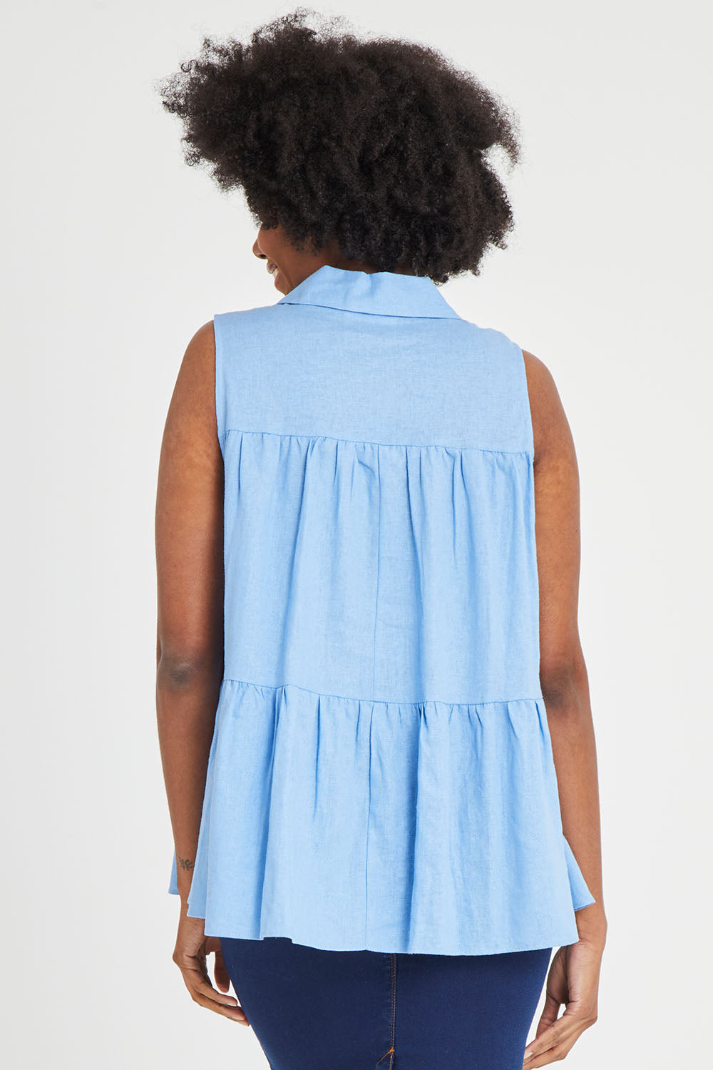 Model Aiyana wearing size 10 of the Prague Paneled Blouse in colour Cornflower (Blue), from the back