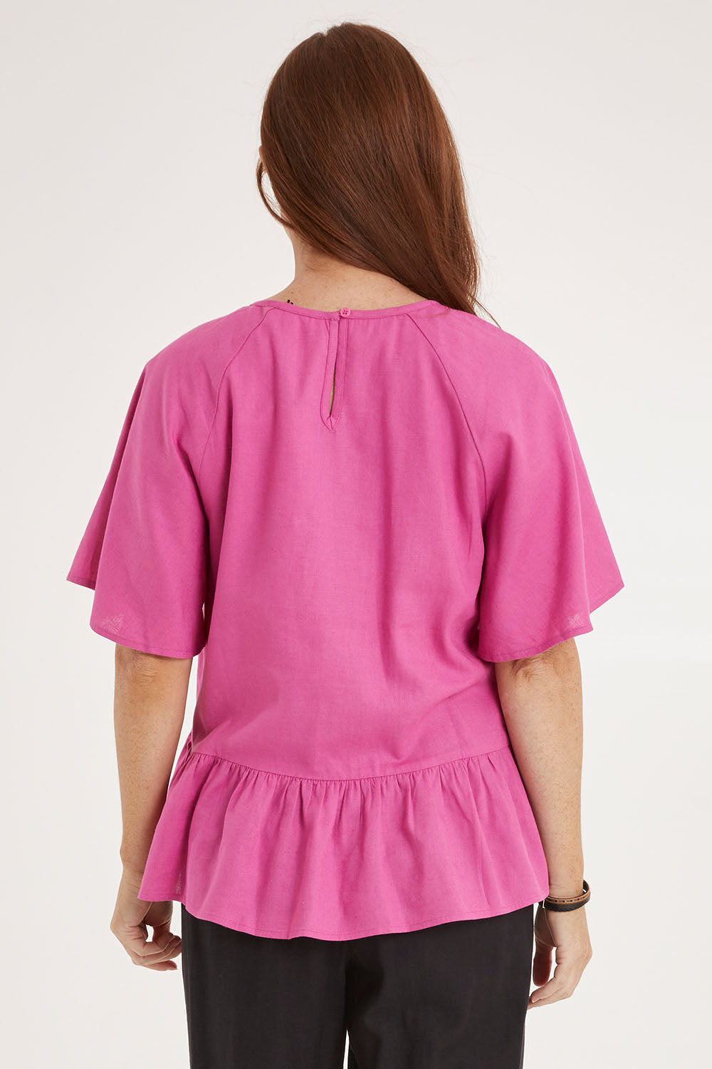 Model Sally wearing size 10 of the Cassandra Top in colour Azalea (Pink), from the back
