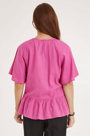 Model Sally wearing size 10 of the Cassandra Top in colour Azalea (Pink), from the back