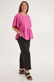 Model Sally wearing size 10 of the Cassandra Top in colour Azalea (Pink), from the front, showing the whole outfit