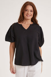 Model Sally wearing size 10 of the Alba Blouse in colour Coal (Black), from the front, cropped image