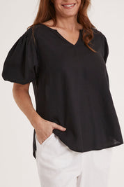 Model Sally wearing size 10 of the Alba Blouse in colour Coal (Black), from the front, cropped image