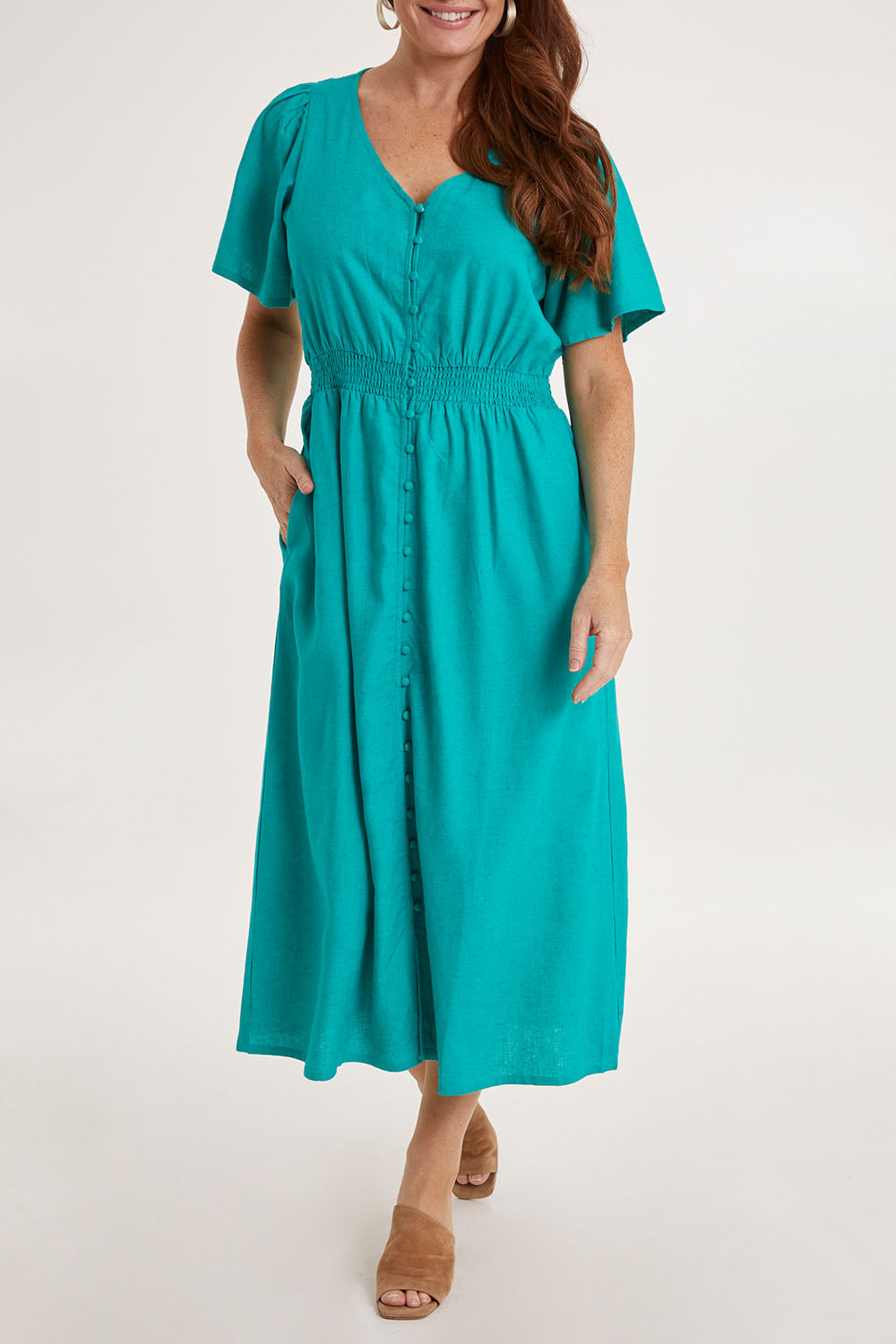Model Sally wearing size 10 of the Whitney Dress in colour Teal (Green), from the front, cropped image