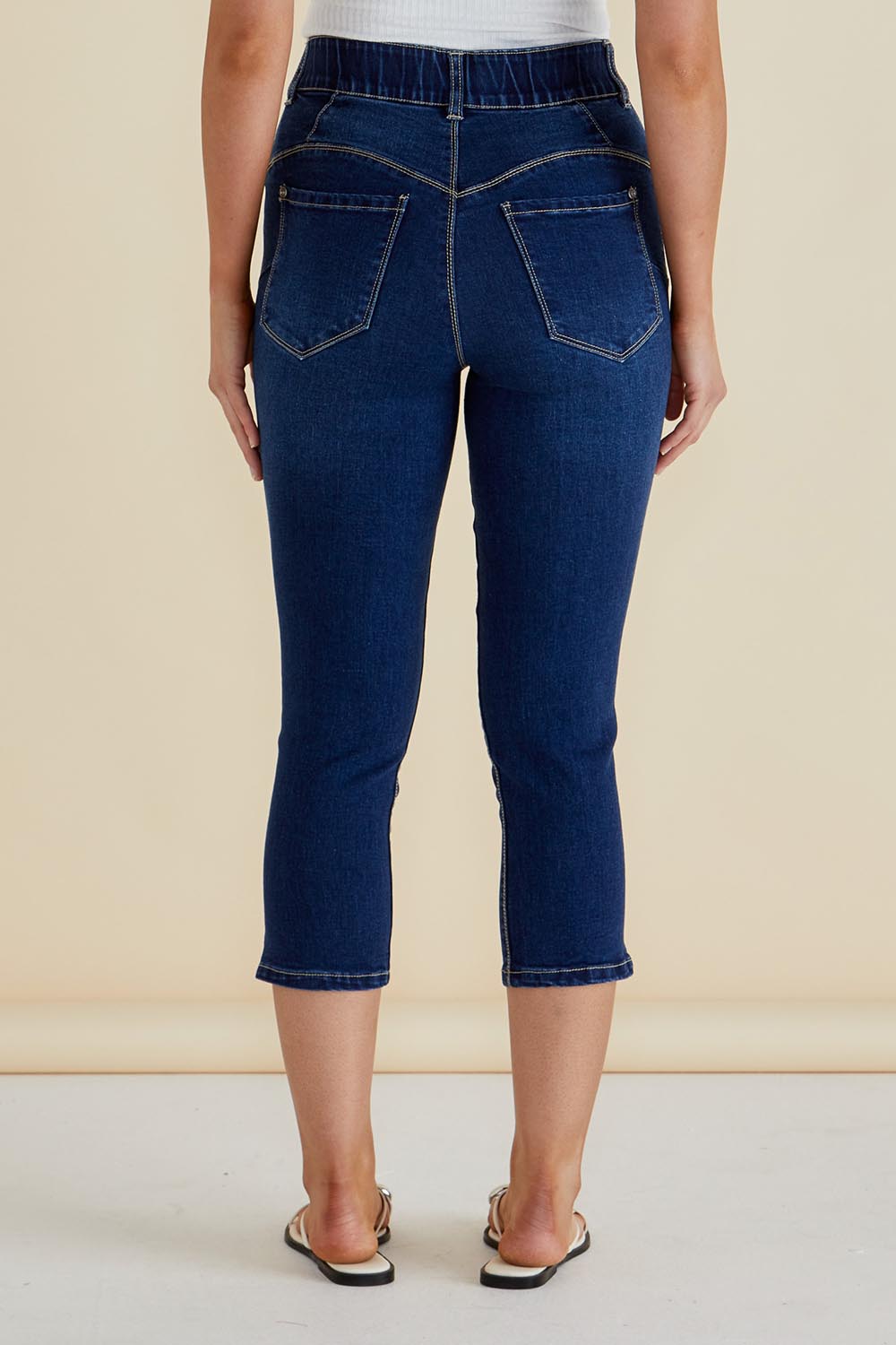 A model wearing the Camila Crop Jeans in colour Midnight (Blue), from the back