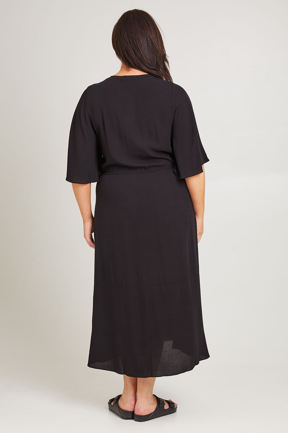 Model Poppy wearing size 16 of the Saint Lucia Dress in colour Black (Black), from the back