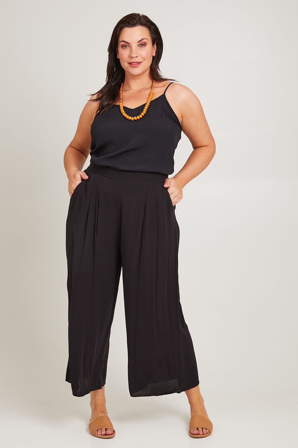 Model Poppy wearing size 16 of the Olympia Pant in colour Black (Black), from the front, showing the whole outfit