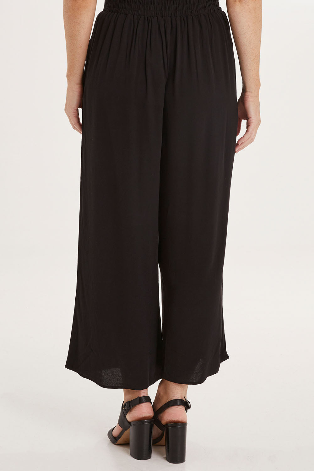 Model Sally wearing size 10 of the Olympia Pant in colour Black (Black), from the back
